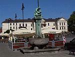 Zabytkowa fontanna na Głównym Rynku. W oddali widać ratusz
